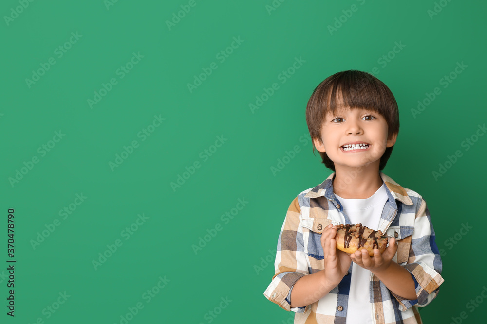 Funny little boy with donut on color background