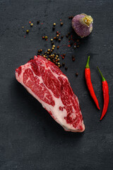 Wall Mural - Fresh uncooked steak with seasoning and chili pepper for grilling, black Angus beef