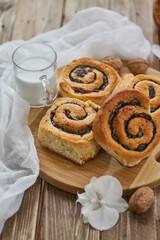 Wall Mural - Basket of homemade buns with jam, served on old wooden table with walnuts and cup of milk