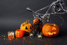 Halloween And Holiday Decorationsconcept - Jack-o-lantern Or Carved Pumpkin, Burning Candles, Electric Garland String, Spiders And Bats On Spiderweb