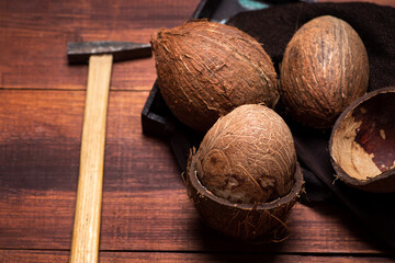 Wall Mural - Open coconut and a small hammer on a wooden table top view