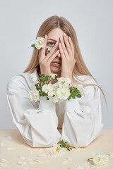 Wall Mural - Beauty art portrait of a woman with rose flowers in her hands. Natural cosmetics for hands and face