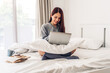 © Art_Photo - Young smiling happy beautiful asian woman relaxing using laptop computer in the bedroom at home. Young creative girl working and typing on keyboard.work from home concept