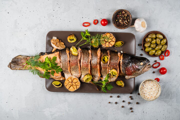 Wall Mural - Baked stuffed fish carp with vegetables. on a gray background