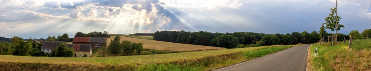 Naklejka na meble Thunderstorm clouds are gathering over a rural landscape with a Farm and a countryroad between fields in Germany near Velbert Langenberg, Neviges in North Rhine Westphalia