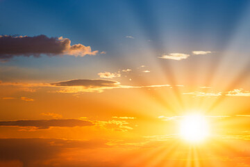 sun rays on sunset sky with blue ond orange colorful sunset clouds