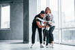© standret - Woman in formal clothes and with camera in hand standing inside of empty room with man and little boy