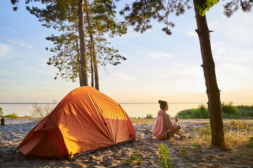 Charming female traveler drinking coffee on the beach