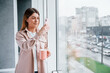 © standret - Young girl in casual clothes standing indoors with her phone in hand
