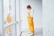 © standret - Female worker or engineer in yellow uniform and hard hat standing indoors