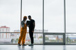© standret - Female worker or engineer in yellow uniform and hard hat standing indoors with man