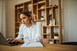 © bnenin - Portrait of a young businesswoman working on laptop computer, close-up.