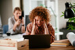 © JustLife - Tired businesswoman working on laptop. Young businesswoman working in the office..