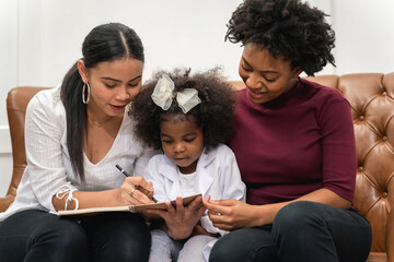 LGBT diversity Lesbian Couple Moments Happiness with her african girl laughing and drawing picture