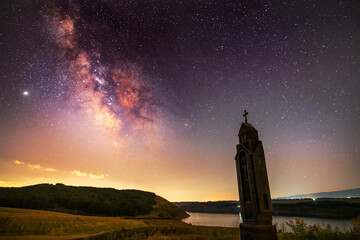Wall Mural - beautiful night landscape, starry sky with bright milky way galaxy above the lake. old armenian chri
