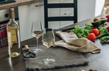 Wine bottle and two glasses on kitchen background.