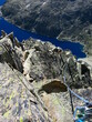 Alpiniste qui grimpe avec corde et casque en escalade sur les arêtes Ferbos du Néouvielle et des trois conseillers montagne dans le Parc National des Pyrénées en France du Languedoc