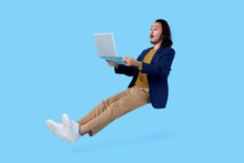 Young Asian Businessman Hand Holding Computer Laptop Floating In Mid-air Isolated On Blue Background.