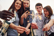 © standret - With sparklers in hands. Group of young people in casual clothes have a party at rooftop together at daytime