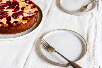 Wall Mural - Homemade Ricotta Plum Cake on beige linen tablecloth. Cottage cheese casserole with vanilla, semolina and plums. Selective focus