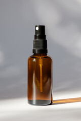 Wall Mural - Cosmetic amber glass bottle with sprayer on white background. Natural organic perfume packaging design