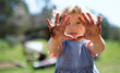 © Halfpoint - Small girl showing dirty hands outdoors in garden, sustainable lifestyle concept.