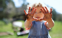 Small Girl Showing Dirty Hands Outdoors In Garden, Sustainable Lifestyle Concept.