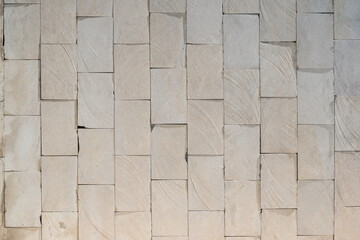 Full screen texture of the wall facing of an old building with sawn white tiles natural marl stone