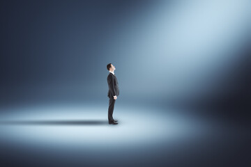 Poster - Businessman standing in illuminated blue interior with spotlight.  Design and art concept.