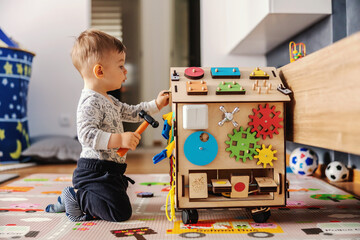 Adorable toddler playing interactive games for good development at home.