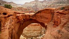 Person Standing On Cassidy Arch In Capitol Reef National Park, Utah, United States