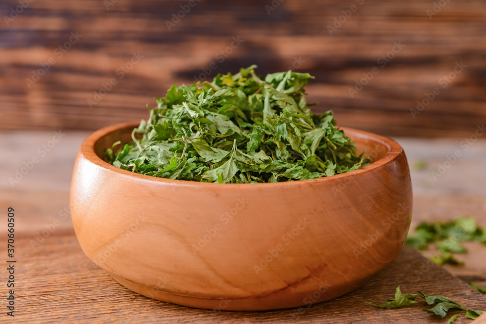 Bowl with dry parsley on table