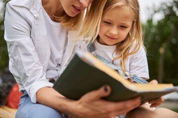 Pretty young girl looking at the page of book