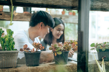 Young couple relax in the garden. They care plant and flower.