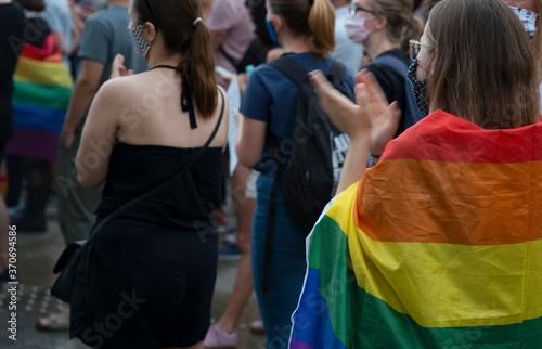 LGBT equality march. Young people wearing rainbow clothes and symbols are fighting for LGBTQ+ rights. Rainbow flags, banners.