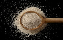 Active Dry Yeast Granules Pile With Wooden Spoon Isolated On Black Background And Texture, Top View With Clipping Path
