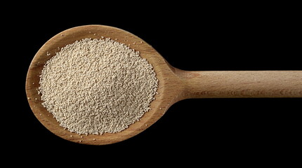 Active dry yeast granules pile with wooden spoon isolated on black background and texture, top view with clipping path