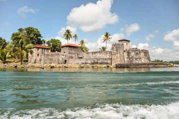 Scenic landscape with Spanish colonial fortress called Castillo de San Felipe de Lara on the water of the Rio Dulce