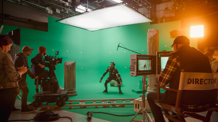 In the Big Film Studio Professional Crew Shooting Blockbuster Movie. Director Commands Cameraman to Start shooting Green Screen CGI Scene with Actor Wearing Motion Capture Suit and Head Rig