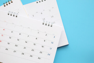 calendar page close up on blue background business planning appointment meeting concept