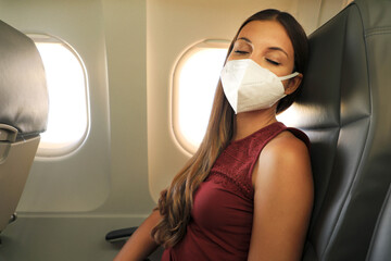 Wall Mural - Brazilian woman with protective face mask sleeping relaxed on airplane flight during pandemic coronavirus