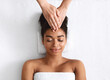 © Prostock-studio - Therapist rubbing black woman forehead at spa