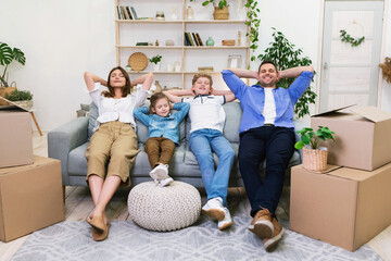 Wall Mural - Family Relaxing Sitting Among Moving Boxes After Relocation Indoors