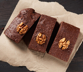 Canvas Print - baked pieces of brownie chocolate cake with nuts on a brown piece of paper