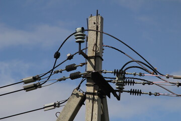 old power lines with many wires on the background of blue sky