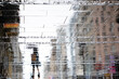Blurry reflection shadow silhouette on wet street of a woman walking on a rainy day