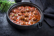 Traditional slow cooked American Tex Mex meatballs chili with mincemeat and beans in a spicy sauce offered as close-up in a design cast-iron roasting dish