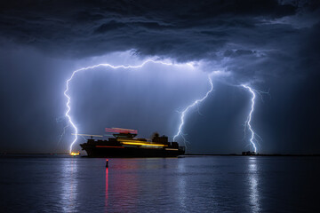 Wall Mural - container ship is leaving the port of antwerp during a severe thunderstorm