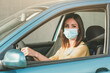© esthermm - Young woman driving car with medical mask on her face