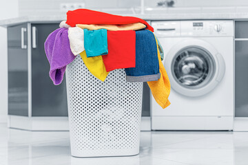 Basket with linen on the background of a washing machine.